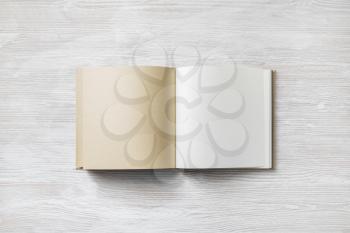 Opened blank booklet or book on light wooden background. Top view. Flat lay.