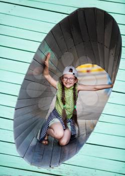 Happy child girl in the playground. Little girl inside a wooden structure. Selective focus.