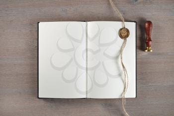 Vintage blank book, sealing wax, stamp and rope on wooden background. Flat lay.