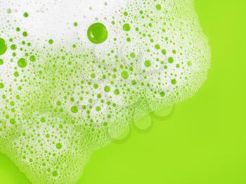 Soap sud on green background. Shampoo in water. Soap foam with bubbles. Flat lay.