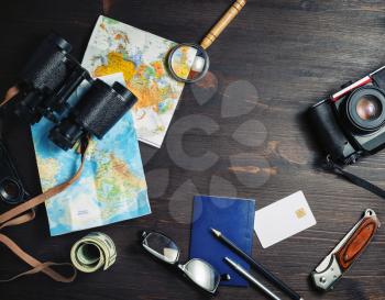 Accessories for travel. Traveler's outfit and vacation items on vintage wood table background. Top view. Flat lay.