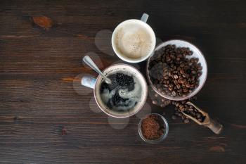 Coffee on wooden table background. Coffee cups, roasted coffee beans and ground powder. Flat lay.