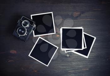 Blank photos and vintage camera on wooden background. Square photo frames template. Flat lay.