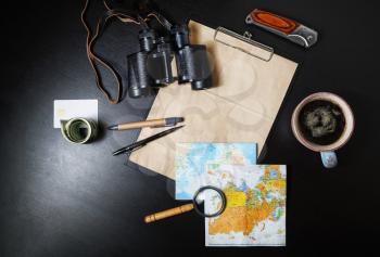 Planning vacation trip. Traveler's accessories on black table background. Preparation for travel. Top view. Flat lay.