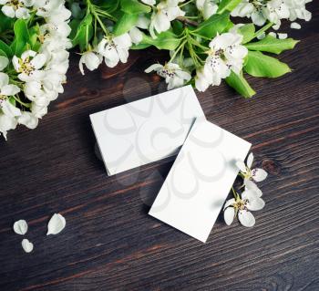 Blank business cards and flowers on wood table background. Template for ID.