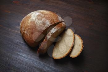 Sliced traditional bread on wood table background.