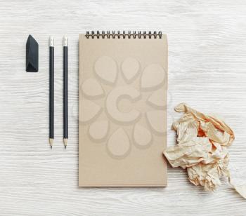 Kraft stationery template. Photo of blank vintage notepad, pencil, eraser and crumpled paper on light wood table background. Top view. Flat lay.