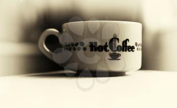 Horizontal vintage hot cup of coffee bokeh vignette background with dust particles