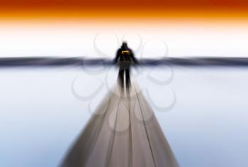 Horizontal radial blur man on pier abstract with orange sky background