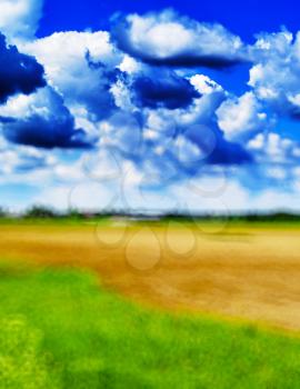 Vertical blurred abstract landscape with real clouds background