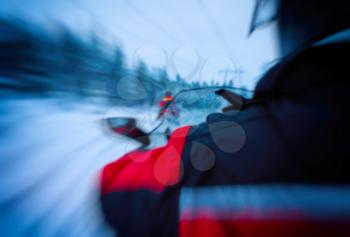 Horizontal vivid snowmobile rider blurred background