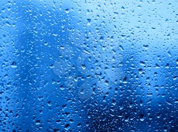 Dramatic rain drops of water on the window glass background