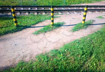 Railroad stop limiters on summer path backdrop