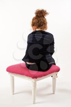 Little girl in black suit sitting back