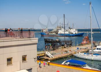 Odessa, Ukraine - 04.20.2019. Tourists look at the harbor and seaport of Odessa on a sunny spring day