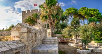 Kusadasi, Turkey – 07.18.2019.  Kusadasi castle in Turkey and pleasure boat parking on a summer evening