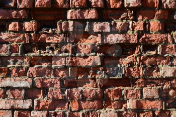Destroyed by time and precipitation brick wall. The Background of old vintage brick wall