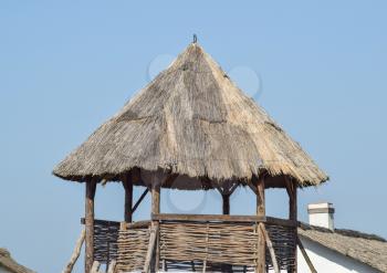 Watchtower with a thatched roof. Wooden observation tower.