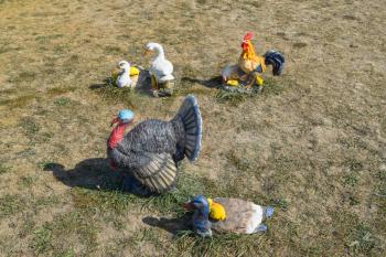 Toy turkeys and chickens in the meadow. Home decorations of the house.