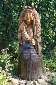 The wooden statue of Baba Yaga in a mortar. Fairy-tale characters Baba Yaga, wooden decoration.