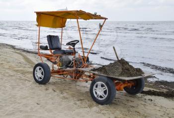 The car for garbage collection from the beach. Cleaning on the beach, clean beach from mud and waste.