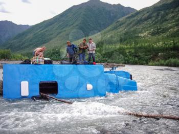 Russia, Nezhdaninskoe - June 23, 2014: An accident while crossing a mountain stream. The car carrying workers overturned and fell into the water.