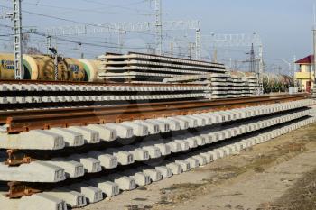 New rails and sleepers. The rails and sleepers are stacked on each other. Renovation of the railway. Rail road for the train.