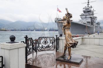 Novorossiysk, Russia - May 28, 2016: Monument to sailor's wife. Warship Admiral Kutuzov. The area of Novorossiysk Sea Commercial Port.