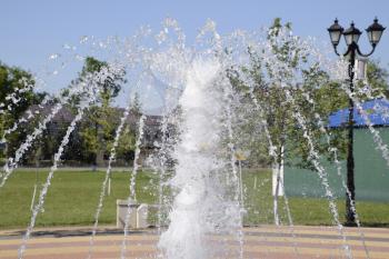 Splashes of a fountain in the park. Beautiful water jet emitted fountain.
