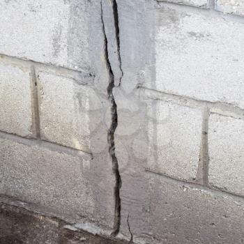 A crack in the concrete wall. The destruction of the wall from the gray blocks.