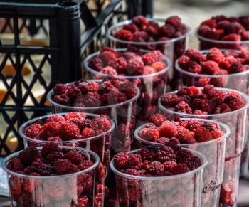 Glasses with raspberries on the counter. Sale of raspberry.