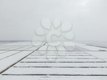 Top view of a plowed field in winter. A field of wheat in the snow.