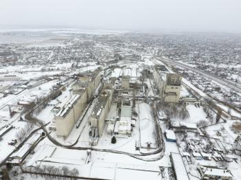 Sprinkled with snow grain elevator. Winter view of the old Soviet elevator. Winter view from the bird's eye view of the village. The streets are covered with snow.