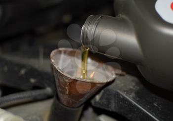 Oil change in the engine of the car. Filling the oil through the funnel. Car maintenance station