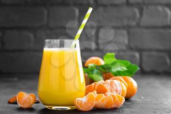Tangerines, peeled tangerines and tangerine juice in glass. Mandarine juice and fresh fruits with leaves.