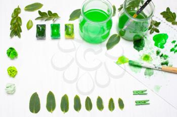 Green leaves draws the artist. Concept art.Ccreative concept, creativity.Workplace, designer table.Flat lay, overhead view