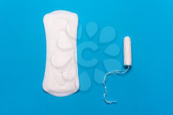 Women's hygiene products, pad, tampon on a blue background. Concept of critical days, menstrual cycle, menstruation