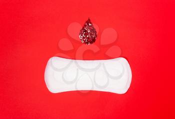On the coral red background is a feminine, hygienic lining. The concept of critical days, menstruation