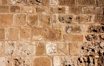 Old, brown, sandy, wall of a stone house in the open air. Seamless texture background rocks, bricks