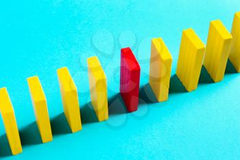 The concept of leadership, individuality. Red domino on yellow background