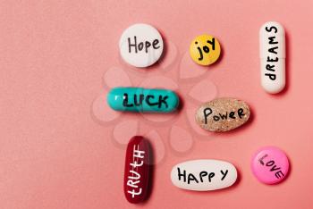 The concept of creative pills, a placebo with joy, love, happiness, truth, power, dream on a pink background