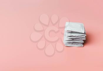 Condom on a pink background. The concept of safe sex, stopping the transmission of sexually transmitted diseases, STDs, AIDS, unwanted pregnancy, an alternative to abortion