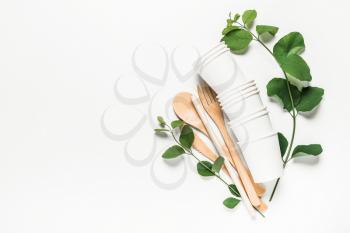 Wooden fork, spoon, knife, tube, paper cups on a white background. The concept of recycling, eco, planet conservation, zero waste