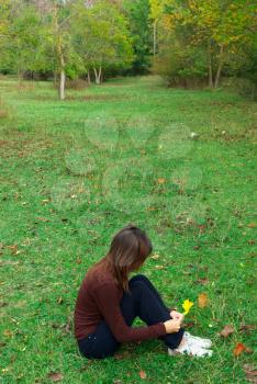 Girl sits  in meadow. Emotional scene.