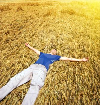 Man lie down in yellow meadow.