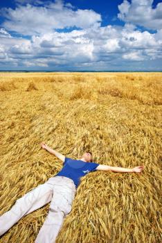 Man lie down in yellow meadow.
