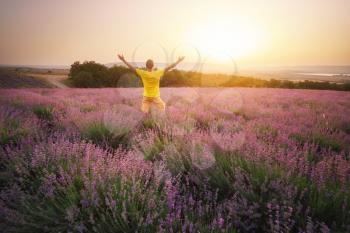 Man in meadow of lavender at sunset. Emotional scene.
