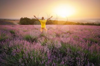 Man in meadow of lavender at sunset. Emotional scene.