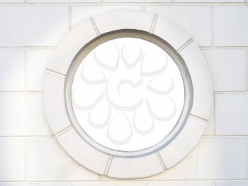 Old white antique round window on wall from stones. Element of design.