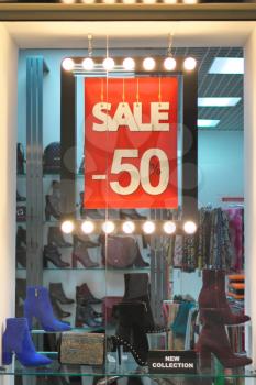 The sale sign notice into a clothes store. Shopping mall advertisement.